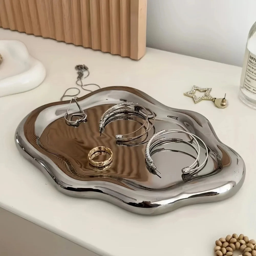 Cloud-shaped white jewelry tray holding rings, earrings, and a watch on a nightstand