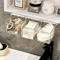 Transparent pull-out storage drawer installed under a bathroom mirror cabinet