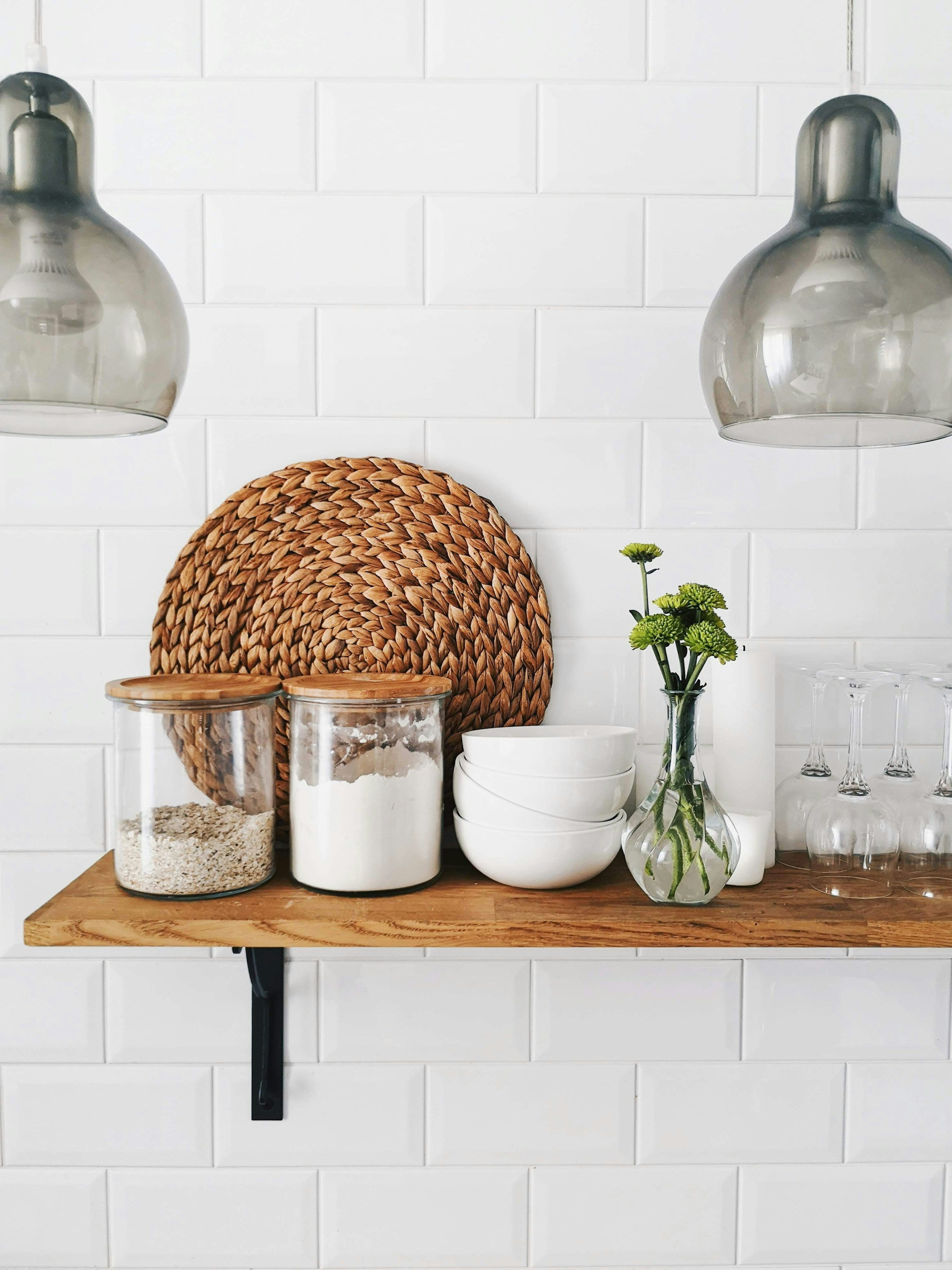 Warm wood shelf with glass storage jars, minimalist home organization styling
